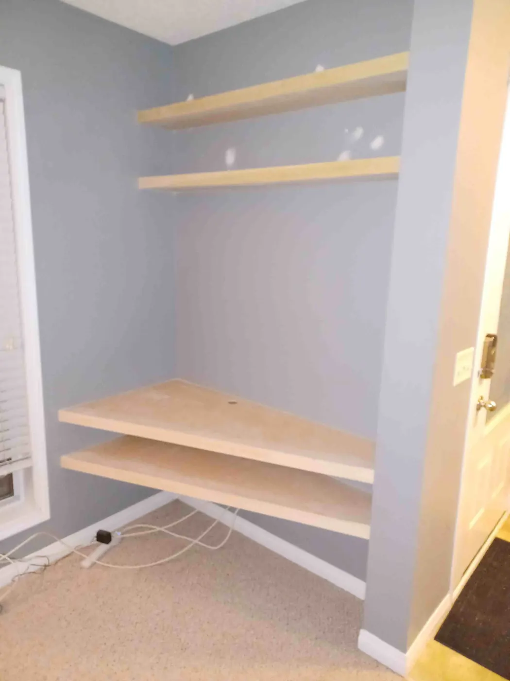 Custom wood media centre with two low floating shelves and two upper floating shelves in a wall alcove