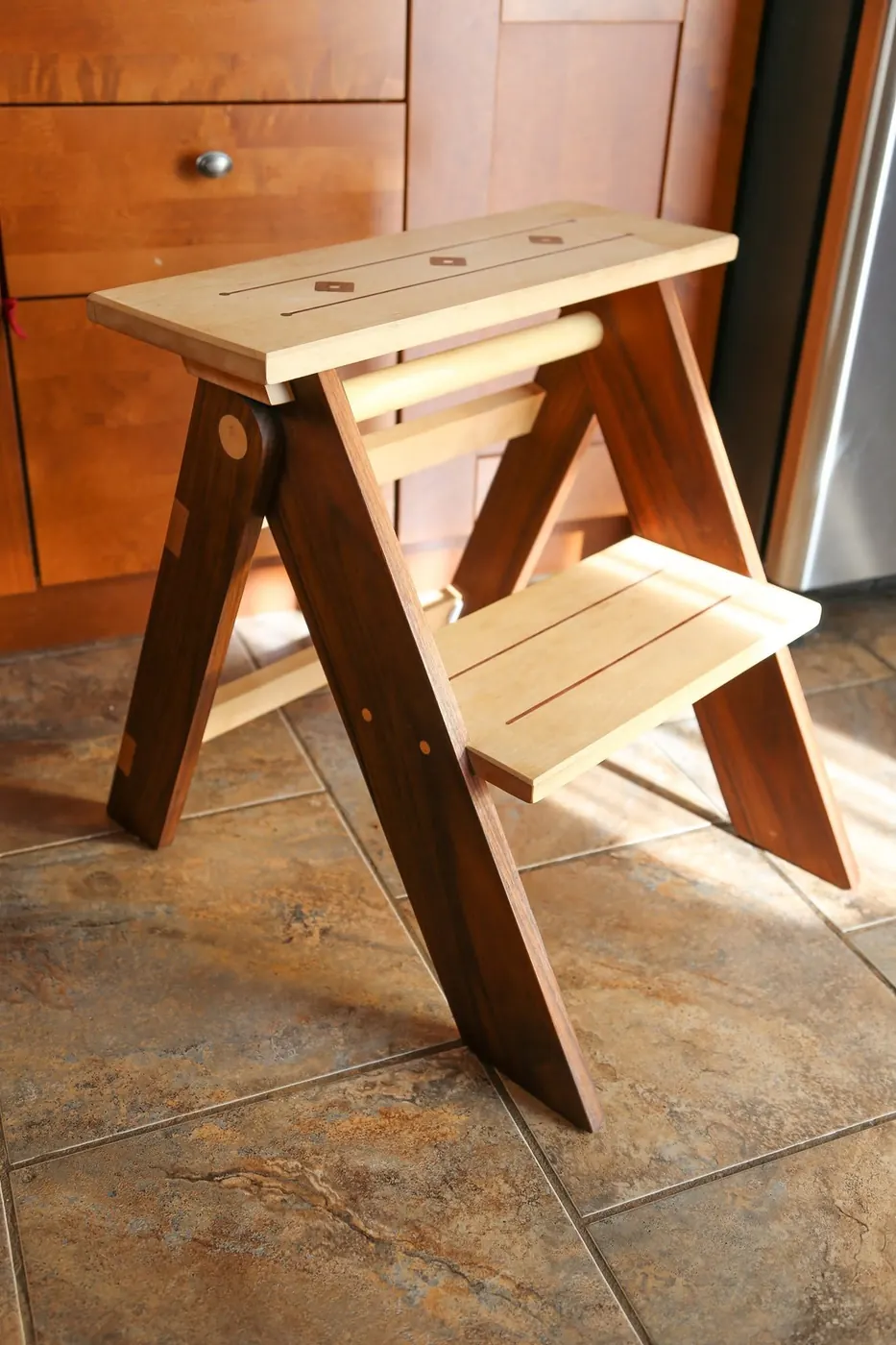 Folding wood step stool made from a light and a dark wood