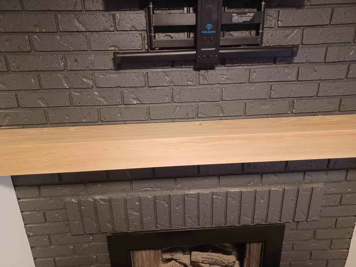 After: a light wood mantel fitted to the same painted brick fireplace