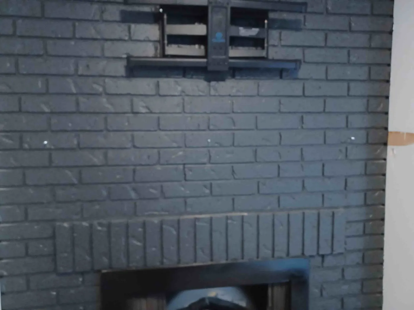 Before: painted brick fireplace with a TV mount and no mantel