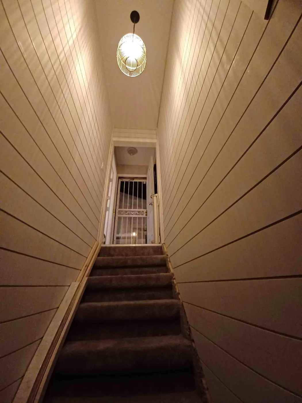 Shiplap walls lining both sides of a stairwell