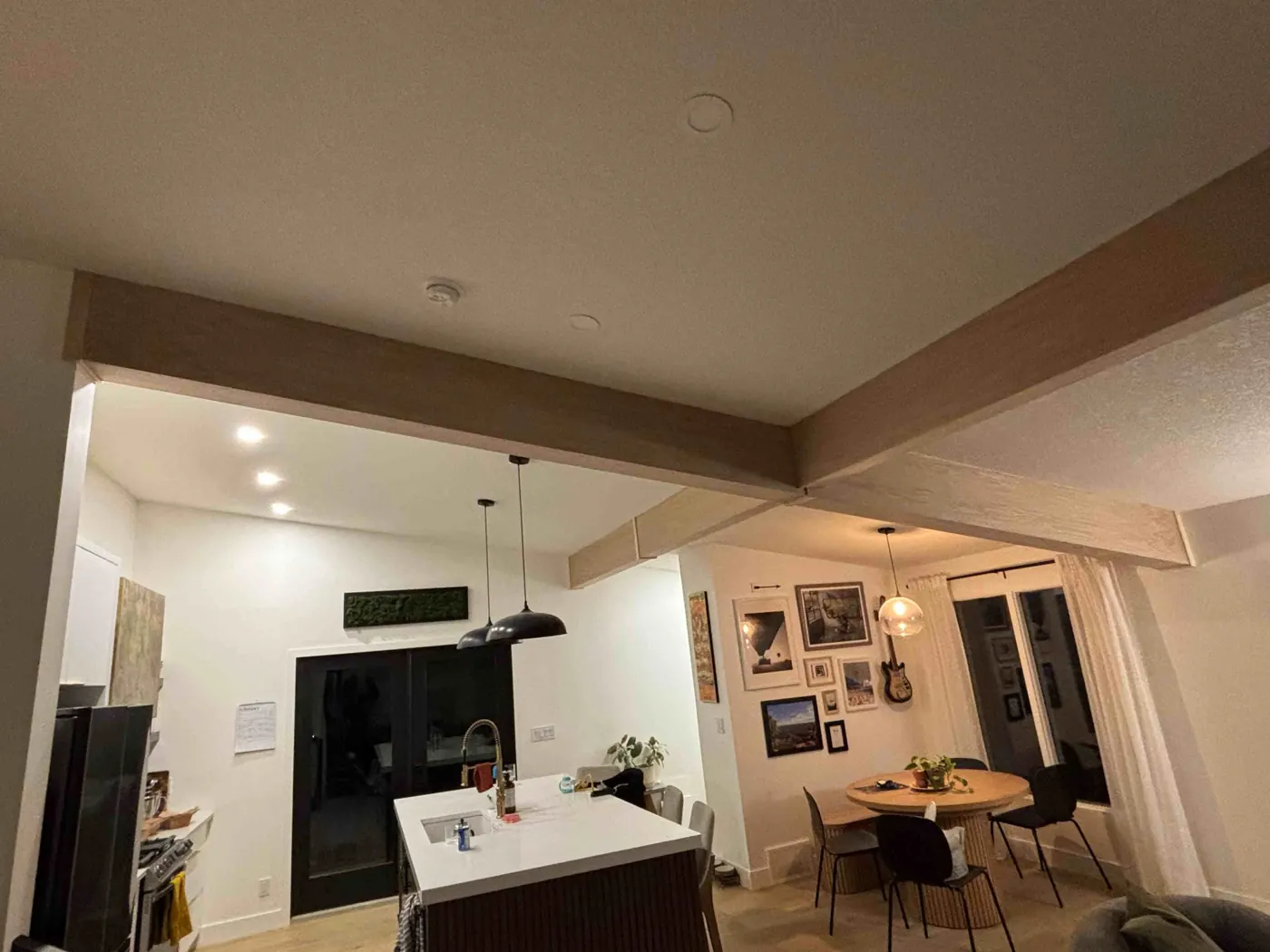 Wood-clad ceiling beams over a kitchen and dining area
