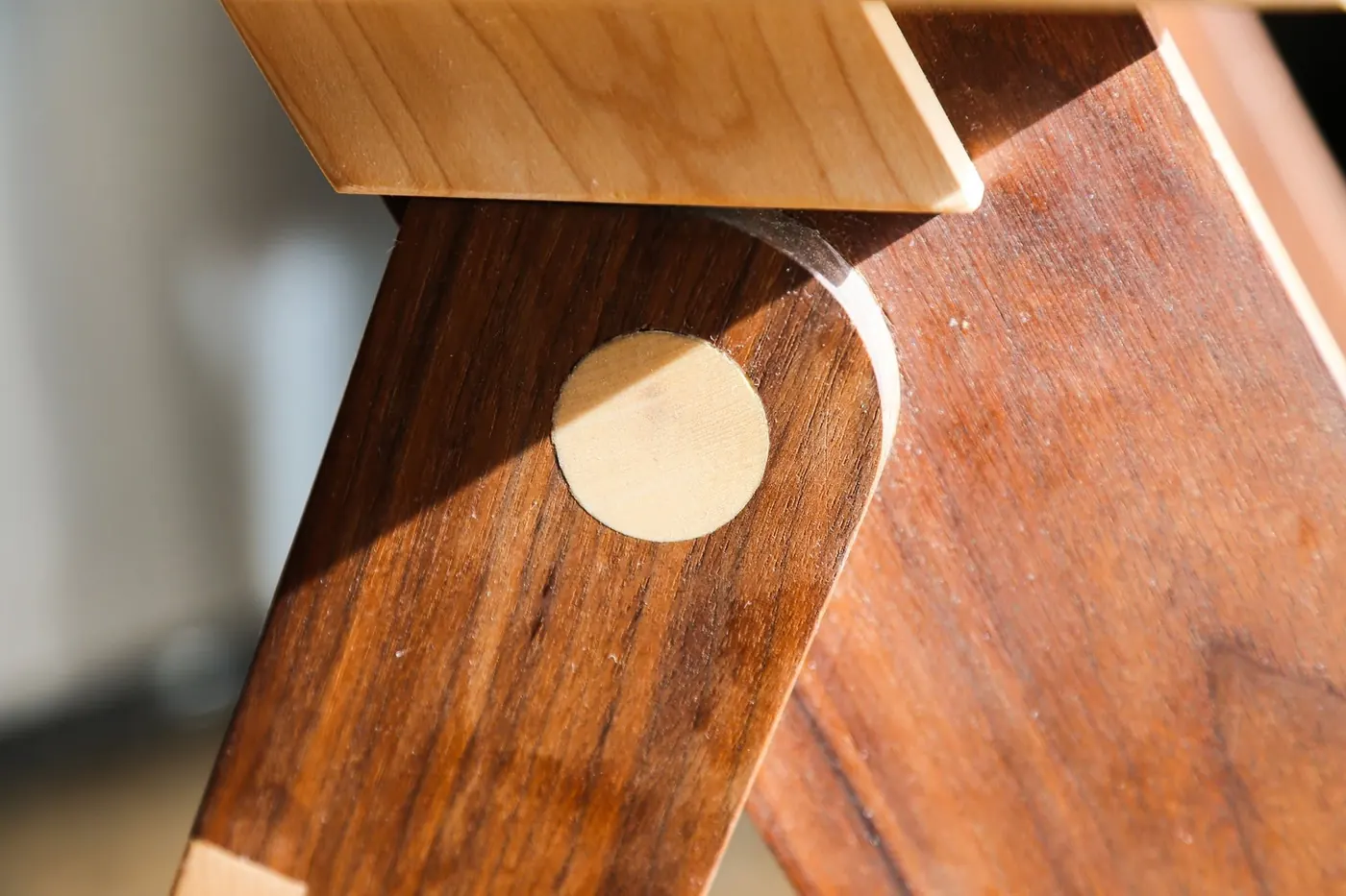 Close-up of a round light wood plug in a dark wood joint