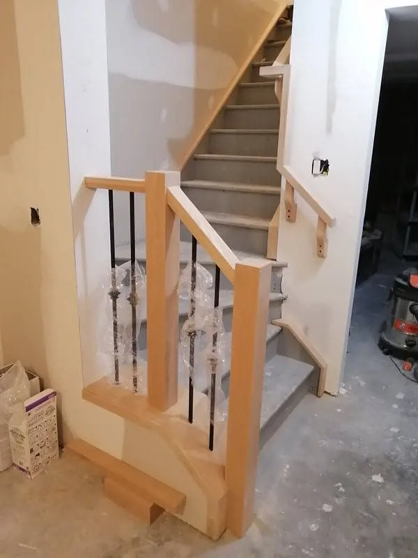 Wood newel post and single knuckle metal spindles during installation
