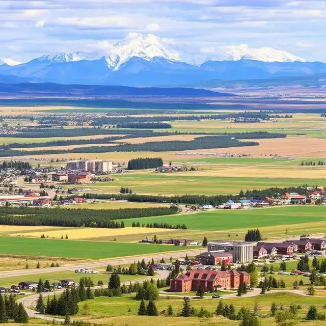 Okotoks, Alberta, with farmland and snow-capped mountains behind the town