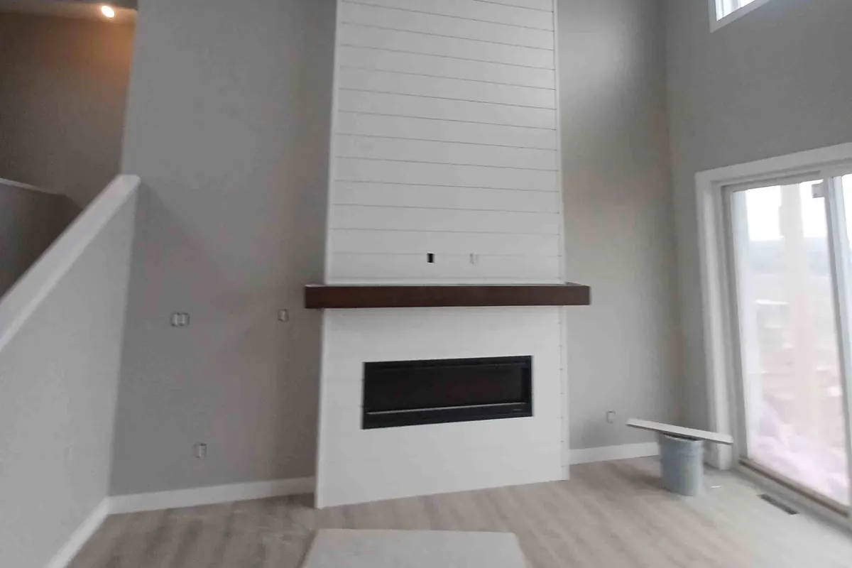 Shiplap fireplace surround with a dark wood mantel